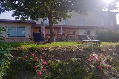 Salle à manger avec table en bois, chaises assorties, escalier en bois, et cuisine ouverte dans un intérieur chaleureux.