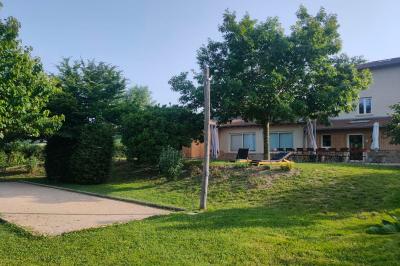 Salle à manger avec table en bois, chaises assorties, escalier en bois, et cuisine ouverte dans un intérieur chaleureux.