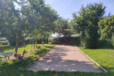 Salle à manger avec table en bois, chaises assorties, escalier en bois, et cuisine ouverte dans un intérieur chaleureux.