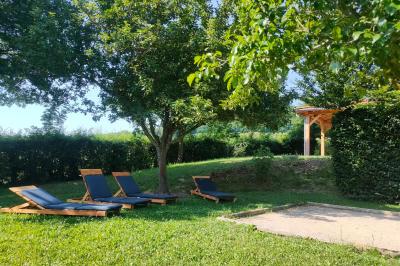 Salle à manger avec table en bois, chaises assorties, escalier en bois, et cuisine ouverte dans un intérieur chaleureux.