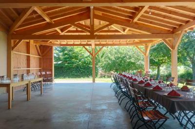 Salle à manger avec table en bois, chaises assorties, escalier en bois, et cuisine ouverte dans un intérieur chaleureux.