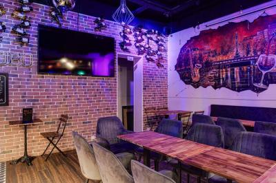 Texte sur un mur en briques indiquant les capacités d'accueil de trois espaces : salle principale, salle au fond, terrasse.