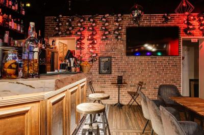 Texte sur un mur en briques indiquant les capacités d'accueil de trois espaces : salle principale, salle au fond, terrasse.