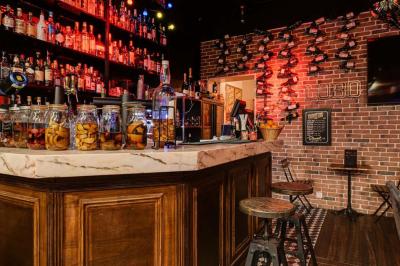 Texte sur un mur en briques indiquant les capacités d'accueil de trois espaces : salle principale, salle au fond, terrasse.