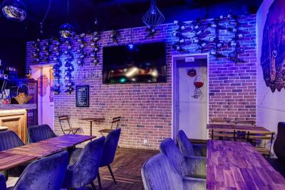 Texte sur un mur en briques indiquant les capacités d'accueil de trois espaces : salle principale, salle au fond, terrasse.