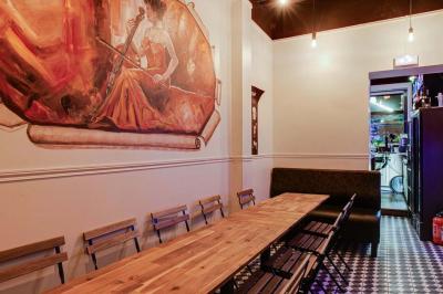 Texte sur un mur en briques indiquant les capacités d'accueil de trois espaces : salle principale, salle au fond, terrasse.