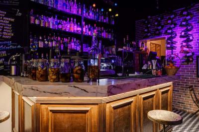 Texte sur un mur en briques indiquant les capacités d'accueil de trois espaces : salle principale, salle au fond, terrasse.