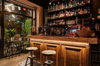 Texte sur un mur en briques indiquant les capacités d'accueil de trois espaces : salle principale, salle au fond, terrasse.