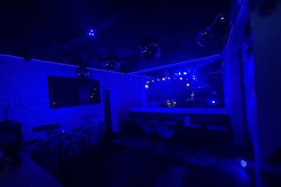 Texte sur un mur en briques indiquant les capacités d'accueil de trois espaces : salle principale, salle au fond, terrasse.