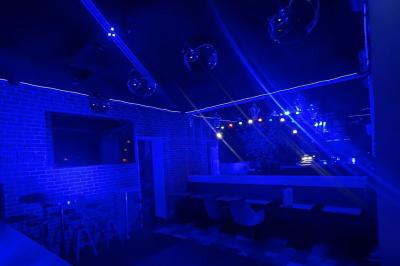 Texte sur un mur en briques indiquant les capacités d'accueil de trois espaces : salle principale, salle au fond, terrasse.