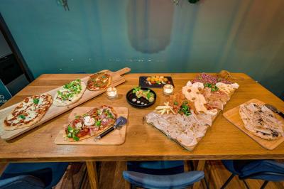 Une rangée de bouteilles de vin variées alignées sur un comptoir en bois, avec un bar en arrière-plan.