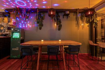 Une rangée de bouteilles de vin variées alignées sur un comptoir en bois, avec un bar en arrière-plan.