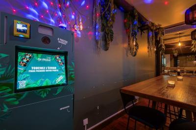 Une rangée de bouteilles de vin variées alignées sur un comptoir en bois, avec un bar en arrière-plan.