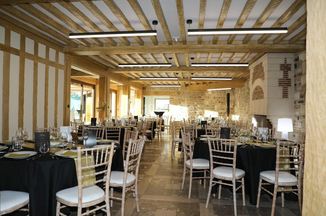 Location salle Saint-Samson-de-la-Roque (Eure) - Manoir Néo Normand #6 Salle de réception lumineuse avec tables dressées, chaises en bois clair et poutres apparentes au plafond.