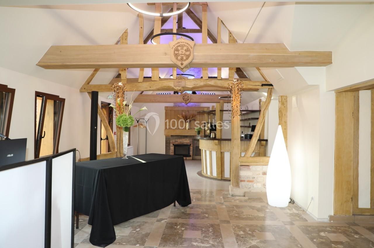 Location salle Saint-Samson-de-la-Roque (Eure) - Manoir Néo Normand #7 Intérieur d'une salle avec poutres apparentes en bois, comptoir en fond et sol en pierre.