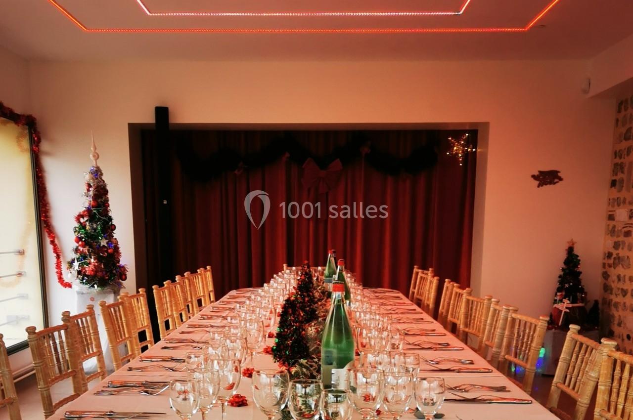 Location salle Saint-Samson-de-la-Roque (Eure) - Manoir Néo Normand #8 Grande table dressée pour un repas festif, décorée de guirlandes rouges et entourée de chaises en bois.