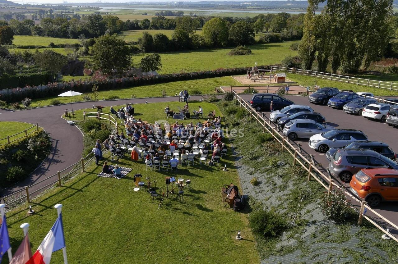 Location salle Saint-Samson-de-la-Roque (Eure) - Manoir Néo Normand #14 Vue aérienne d'un rassemblement en plein air avec des chaises disposées sur une pelouse, entouré de voitures et de paysages…
