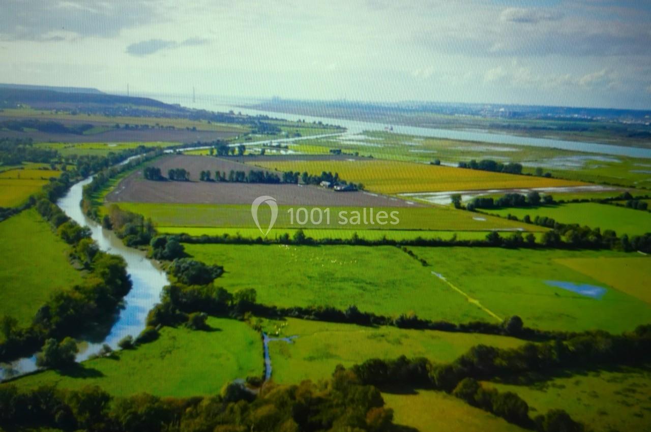 Location salle Saint-Samson-de-la-Roque (Eure) - Manoir Néo Normand #22 Vue aérienne d'une campagne verdoyante avec des champs, un cours d'eau sinueux et un horizon dégagé.
