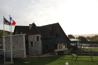 Miniature Location salle Saint-Samson-de-la-Roque (Eure) - Manoir Néo Normand #27 Aire de jeux en bois sur sol sablonneux, entourée de verdure et située près de bâtiments ruraux sous un ciel bleu.