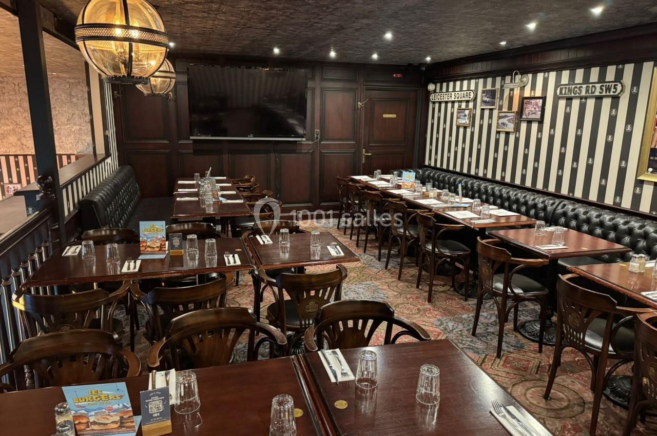 Salle de restaurant au style rétro avec tables en bois, chaises assorties, banquettes noires et décoration murale rayée.