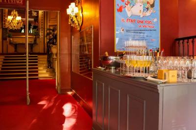 Miniature Espace restauration Entrée d'un théâtre avec comptoir rouge, escalier central, affiches murales et éclairage tamisé.