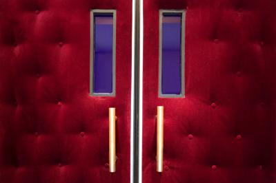 Comptoir rétro dans un hall avec une table et deux chaises, affiches murales et signalétique visible.