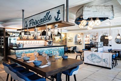 Miniature Location salle Chambray-lès-Tours (Indre-et-Loire) - Léon Fish Brasserie Tours #2 Façade éclairée d'un restaurant au style architectural traditionnel, prise de nuit avec un ciel sombre.