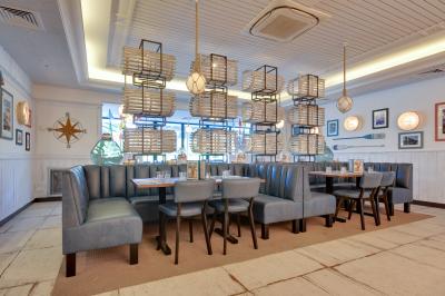 Miniature Location salle Chambray-lès-Tours (Indre-et-Loire) - Léon Fish Brasserie Tours #4 Façade éclairée d'un restaurant au style architectural traditionnel, prise de nuit avec un ciel sombre.