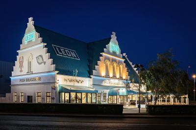 Façade éclairée d'un restaurant au style architectural nordique, avec enseignes lumineuses visibles de nuit.