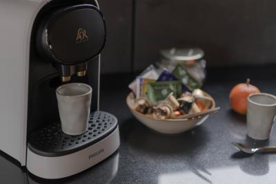Table dressée en extérieur avec boissons fraîches, carafes d'eau infusée, bouteilles et verres sur une nappe blanche.