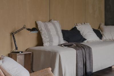 Table dressée en extérieur avec boissons fraîches, carafes d'eau infusée, bouteilles et verres sur une nappe blanche.