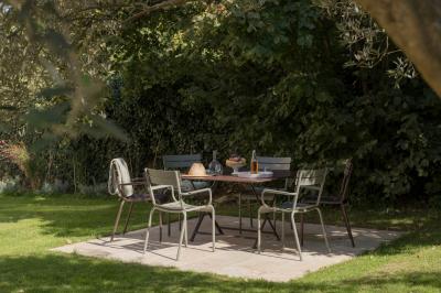 Table dressée en extérieur avec boissons fraîches, carafes d'eau infusée, bouteilles et verres sur une nappe blanche.