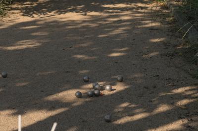 Table dressée en extérieur avec boissons fraîches, carafes d'eau infusée, bouteilles et verres sur une nappe blanche.