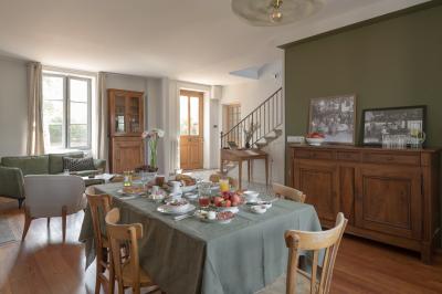 Table dressée en extérieur avec boissons fraîches, carafes d'eau infusée, bouteilles et verres sur une nappe blanche.