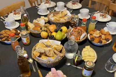 Table dressée en extérieur avec boissons fraîches, carafes d'eau infusée, bouteilles et verres sur une nappe blanche.