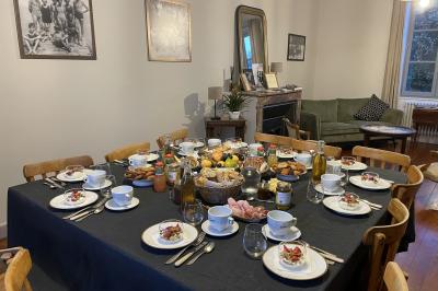 Table dressée en extérieur avec boissons fraîches, carafes d'eau infusée, bouteilles et verres sur une nappe blanche.