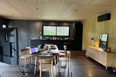 Table dressée en extérieur avec boissons fraîches, carafes d'eau infusée, bouteilles et verres sur une nappe blanche.