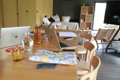 Table dressée en extérieur avec boissons fraîches, carafes d'eau infusée, bouteilles et verres sur une nappe blanche.