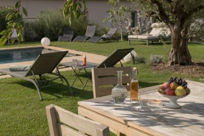 Canapé beige avec coussins blancs et noirs, plaid gris, lampe de bureau noire et table d'appoint en bois.