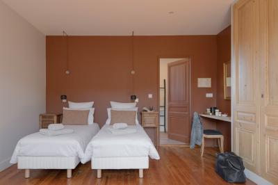 Canapé beige avec coussins blancs et noirs, plaid gris, lampe de bureau noire et table d'appoint en bois.