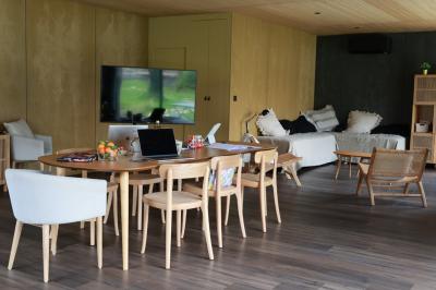 Canapé beige avec coussins blancs et noirs, plaid gris, lampe de bureau noire et table d'appoint en bois.