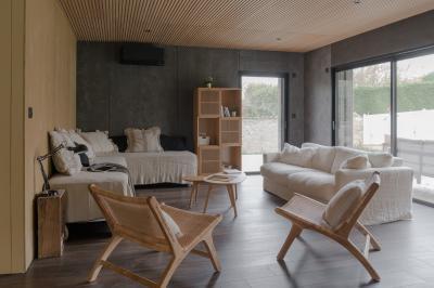 Canapé beige avec coussins blancs et noirs, plaid gris, lampe de bureau noire et table d'appoint en bois.