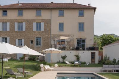 Canapé beige avec coussins blancs et noirs, plaid gris, lampe de bureau noire et table d'appoint en bois.