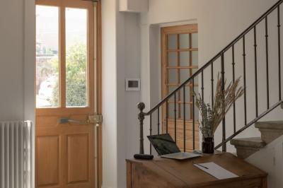 Canapé beige avec coussins blancs et noirs, plaid gris, lampe de bureau noire et table d'appoint en bois.