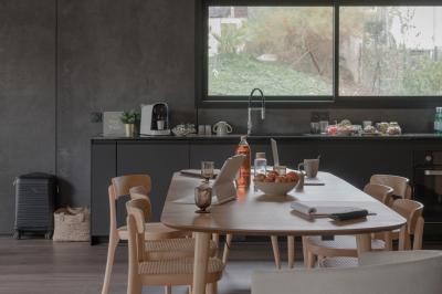 Canapé beige avec coussins blancs et noirs, plaid gris, lampe de bureau noire et table d'appoint en bois.