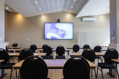 Miniature Location salle Saint-Cyprien (Pyrénées-Orientales) - Grand Hôtel du Lido #4 Bureau en bois avec lampe allumée, chaise colorée et vue sur un balcon donnant sur des arbres et des bâtiments.