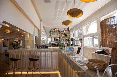 Miniature Location salle Saint-Cyprien (Pyrénées-Orientales) - Grand Hôtel du Lido #7 Bureau en bois avec lampe allumée, chaise colorée et vue sur un balcon donnant sur des arbres et des bâtiments.