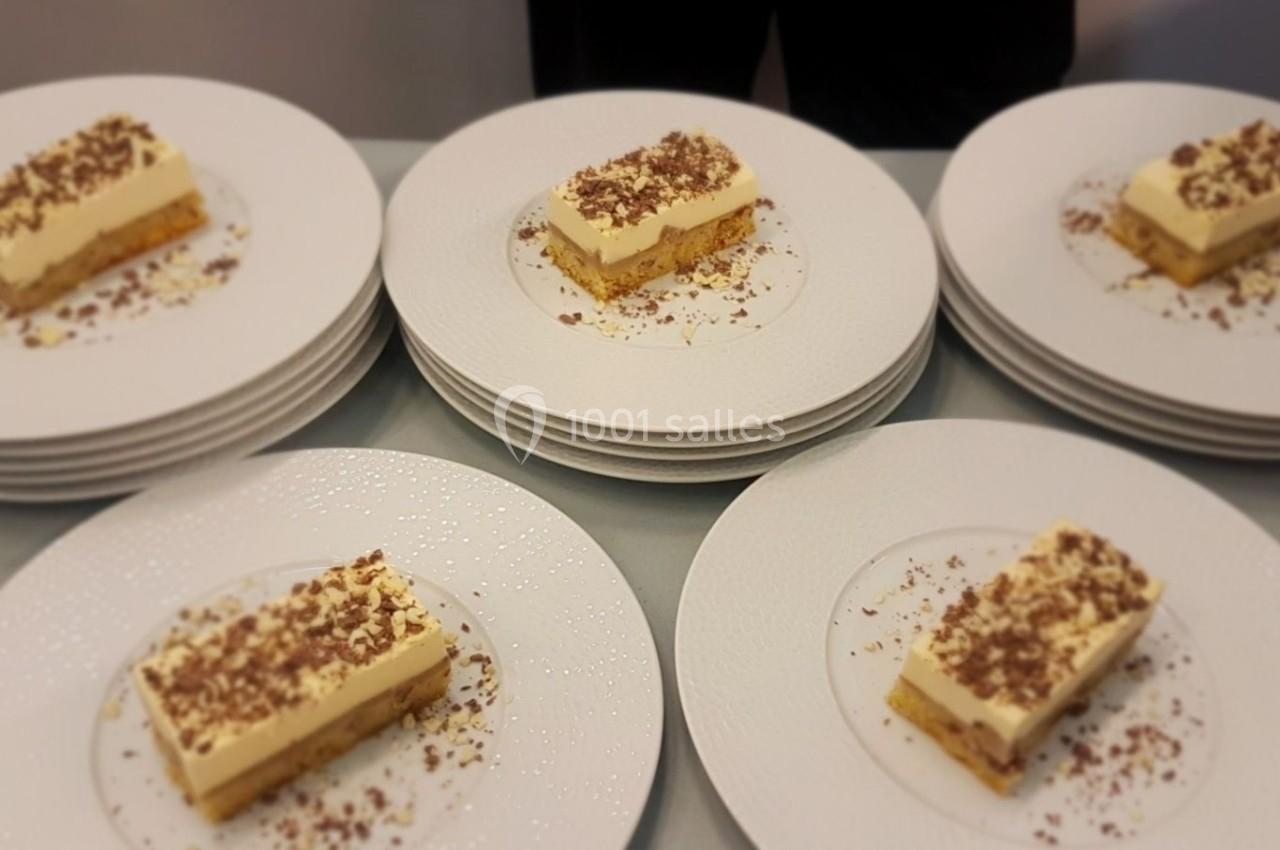 Assiettes de desserts rectangulaires à base de crème et biscuit, garnis de copeaux de chocolat.