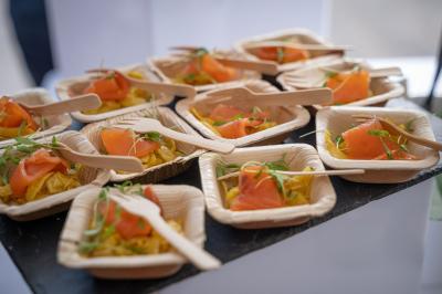 Miniature Pétale de saumon fumé, fenouil mariné huile d'olive et curry et pousse de coriandre Plat dressé avec une base de viande effilochée, purée de pommes de terre, feuilles de salade et sauce en décoration.