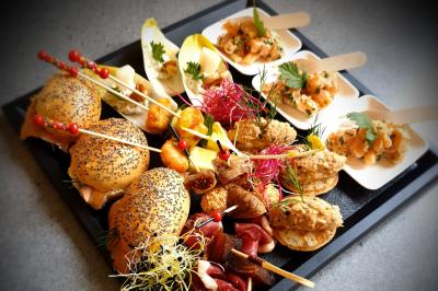 Miniature Plateau de pièces cocktail mixtes Plat dressé avec une base de viande effilochée, purée de pommes de terre, feuilles de salade et sauce en décoration.